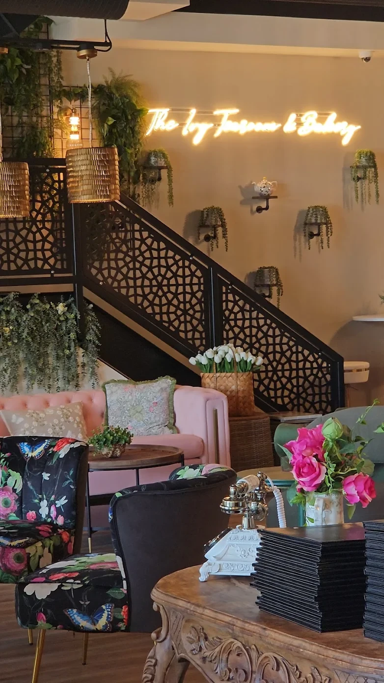 The Ivy lounge area with neon sign and botanical staircase